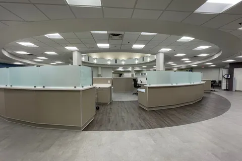 Open office reception area with curved desks beneath a circular ceiling soffit