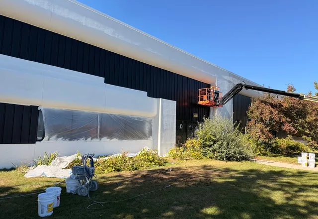 Commercial building exterior being painted from a boom lift