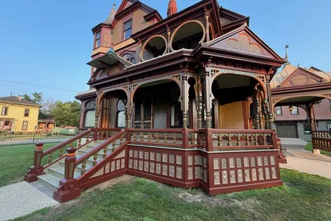 The Hackley House in Muskegon, a Victorian home with ornate wood detailing painted in red and brown tones