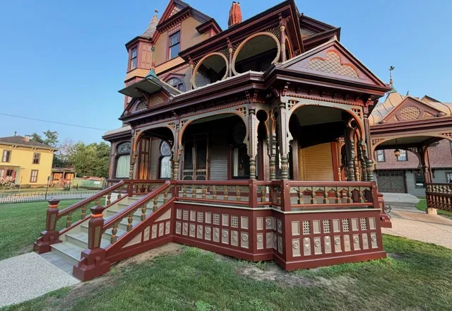 The Hackley House in Muskegon, a Victorian home with ornate wood detailing painted in red and brown tones