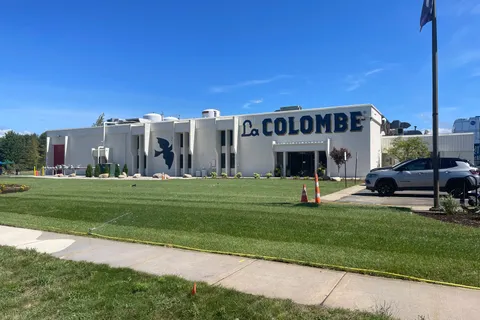 La Colombe building exterior with painted white brick and large navy lettering