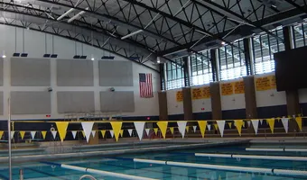 Indoor natatorium with painted trusses and pennant banners