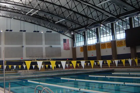 Indoor swimming pool and natatorium with painted trusses and pennant banners