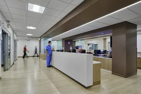 Hospital corridor and nurses' station with dark accent millwork