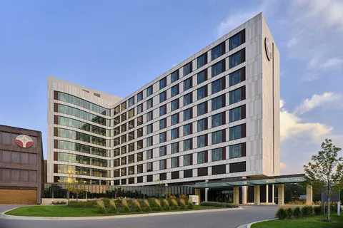 Exterior of a multi-story Trinity Health hospital building at dusk